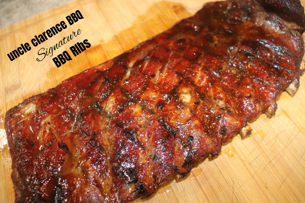 Deliciously smoked Signature BBQ Spare Ribs Recipe with a rich glaze on a wooden board