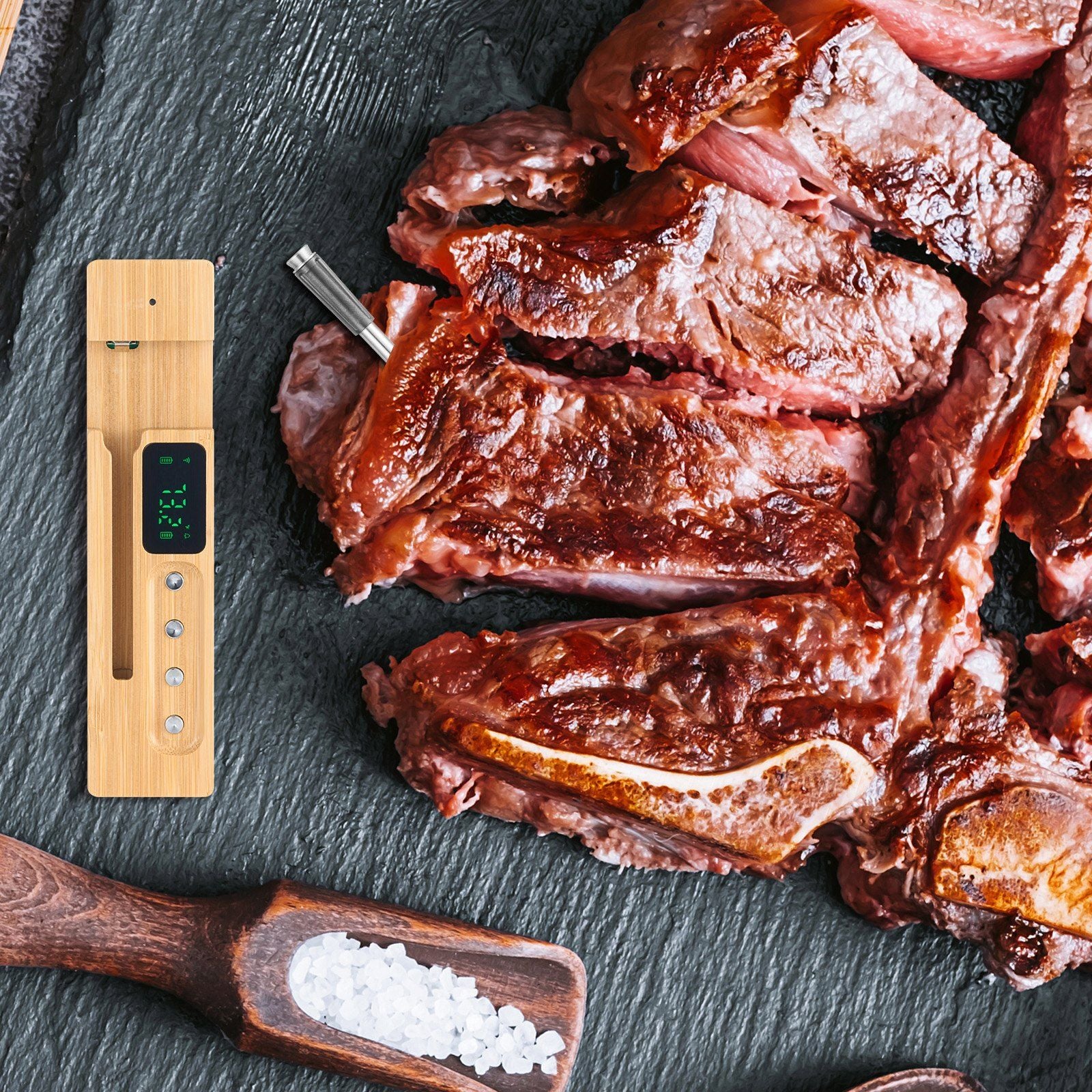 Bluetooth meat thermometer with bamboo design and grilled steaks on a slate serving board