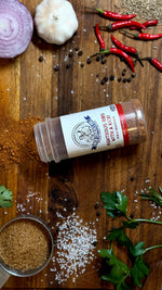 Uncle Clarence BBQ bold rib seasoning mix on a wooden surface with spices and fresh ingredients